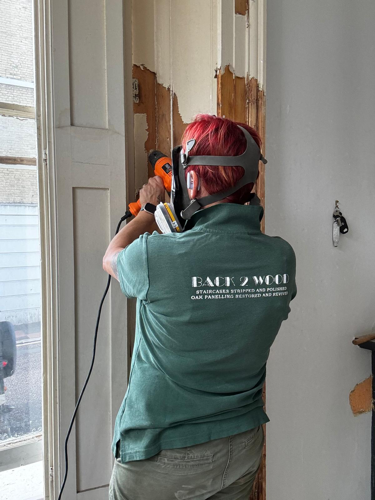 Barbara stripping old paint from panelling on site